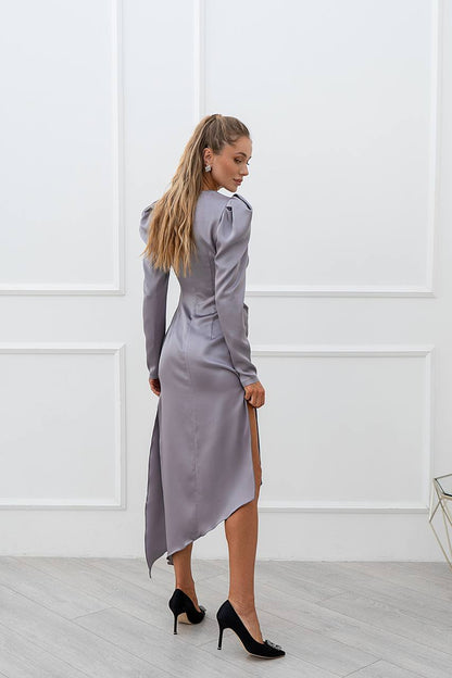 Woman wearing a gray dress with a white wall background