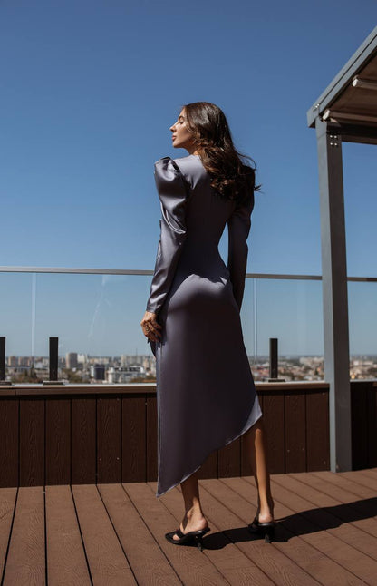 Woman in a gray dress standing on a rooftop with a cityscape in the background