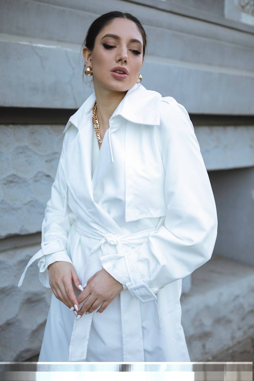 Woman wearing a white coat with a neutral background