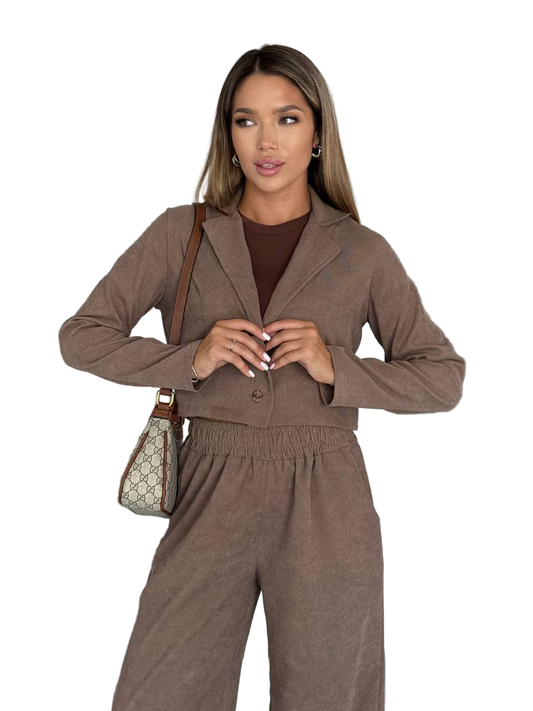 Woman wearing a brown outfit with a matching handbag on a white background