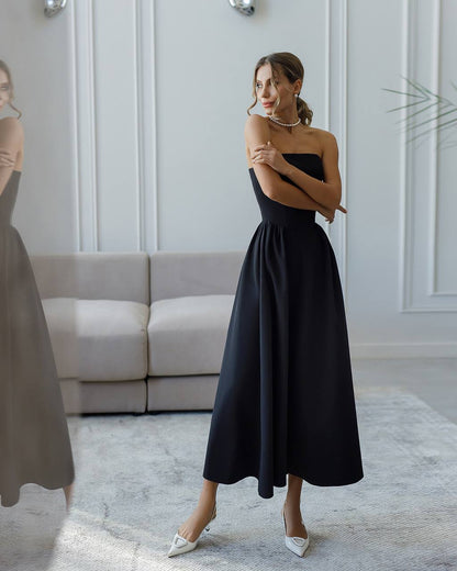 Woman wearing a black strapless dress in a modern interior setting