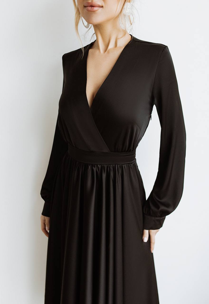 Black long-sleeve dress worn by a person on a white background