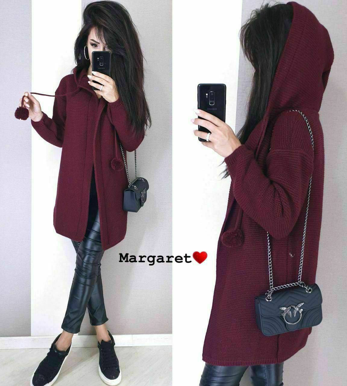 Woman wearing a burgundy hoodie and black leather pants, holding a black handbag.