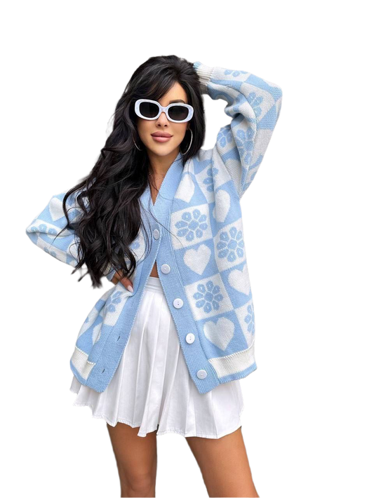 Woman wearing a blue cardigan with white patterns on a white background