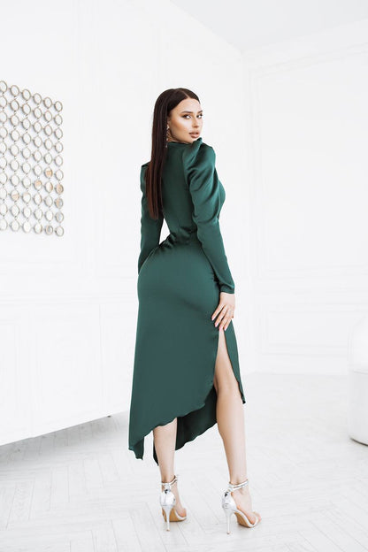 Woman wearing a green dress with a high slit on a white background