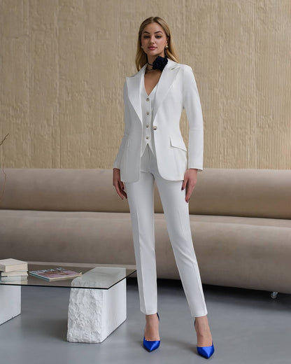 Woman wearing a white suit with blue shoes in a living room setting