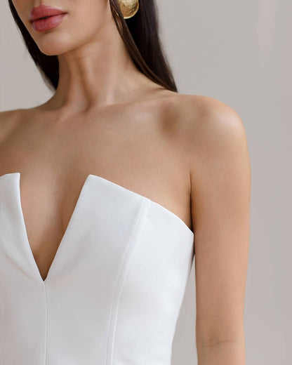 White strapless dress worn by a model with a neutral background
