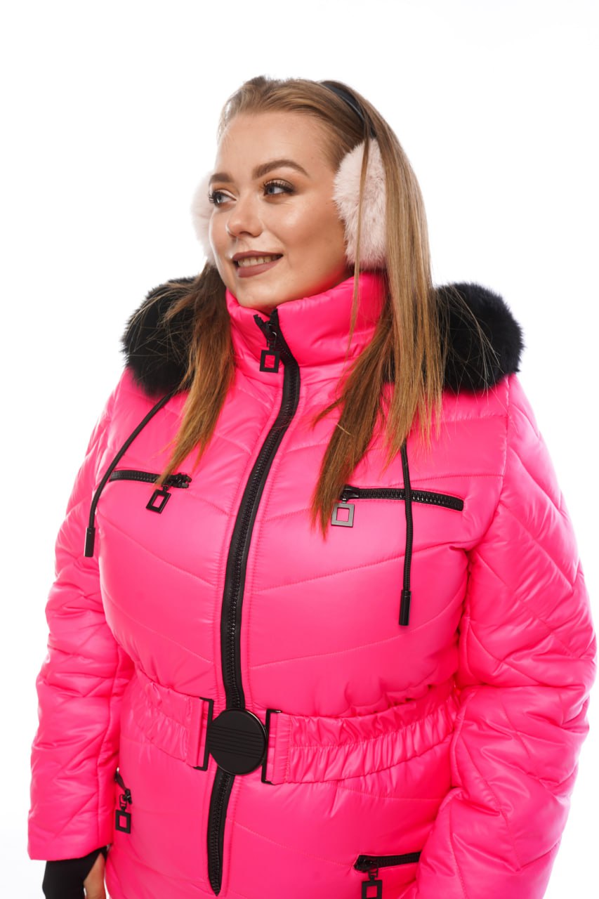 Woman wearing a bright pink winter coat with black fur trim on a white background
