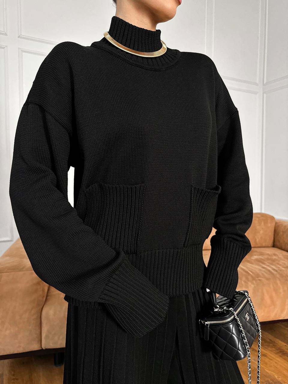 Person wearing a black sweater with a blurred background
