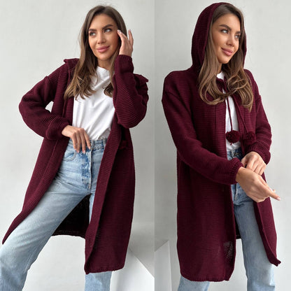 Woman wearing a burgundy cardigan over a white shirt and blue jeans, with and without the hood.