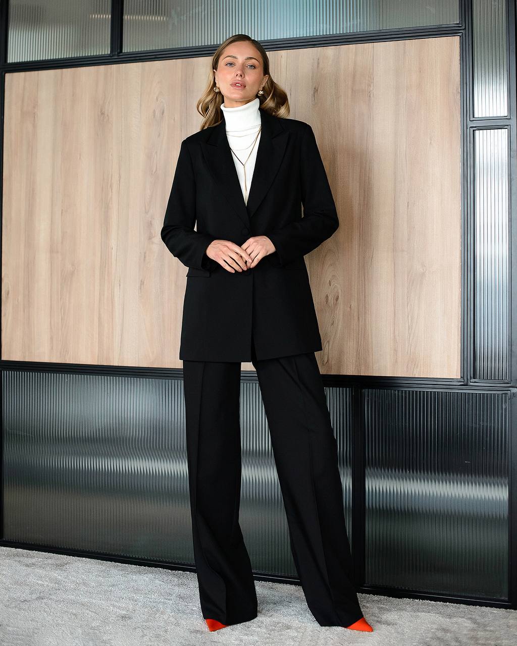 Woman in a black suit standing in an office setting