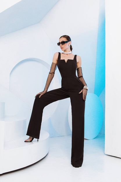Woman in a black outfit sitting on a modern white chair with a blue geometric background