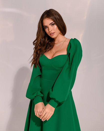 Woman wearing a green dress against a plain background