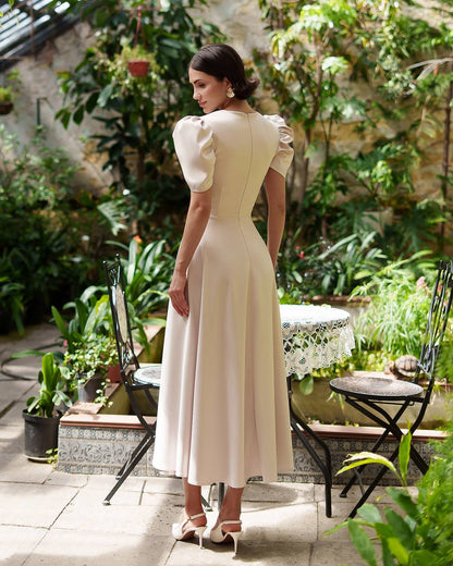 Woman in a white dress standing in a garden setting