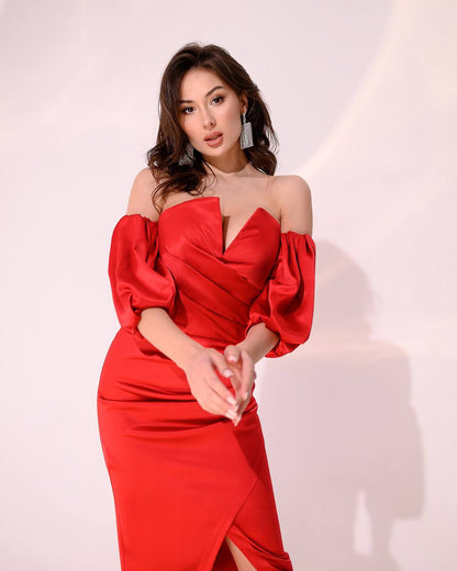 Woman wearing a red off-shoulder dress against a white background