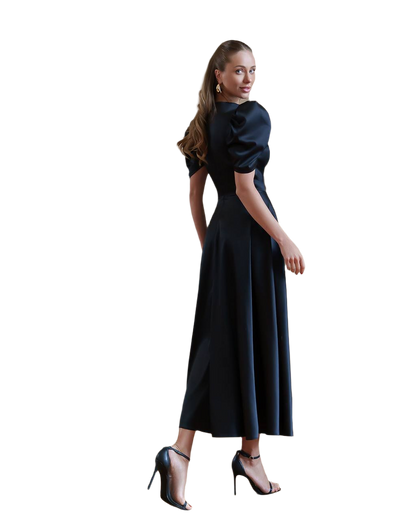 Woman wearing a black dress with puffed sleeves on a white background