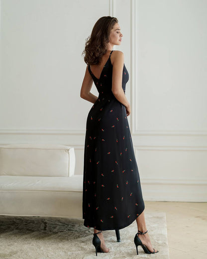 Woman wearing a black dress with a subtle pattern in a room with white walls and a beige carpet.