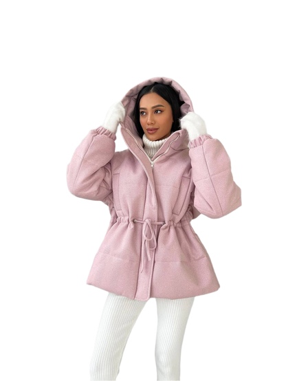 Woman wearing a pink hooded coat on a white background