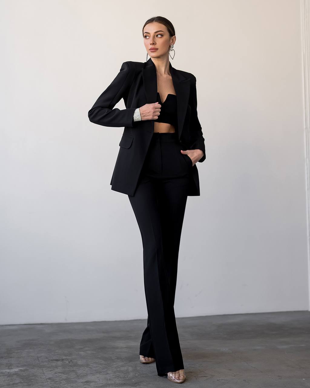 Woman wearing a black suit against a plain background