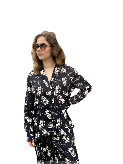 Woman wearing a black floral pajama set on a white background