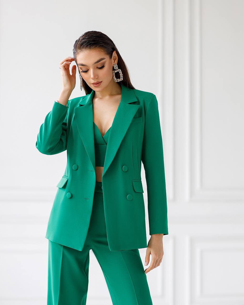 Woman wearing a green suit against a white background