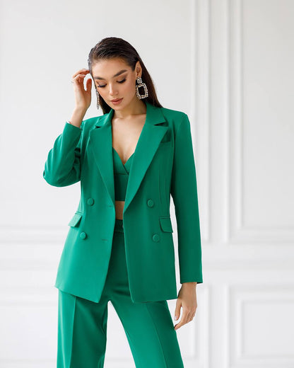 Woman wearing a green suit against a white background