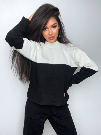 Woman wearing a black and white sweater against a plain background