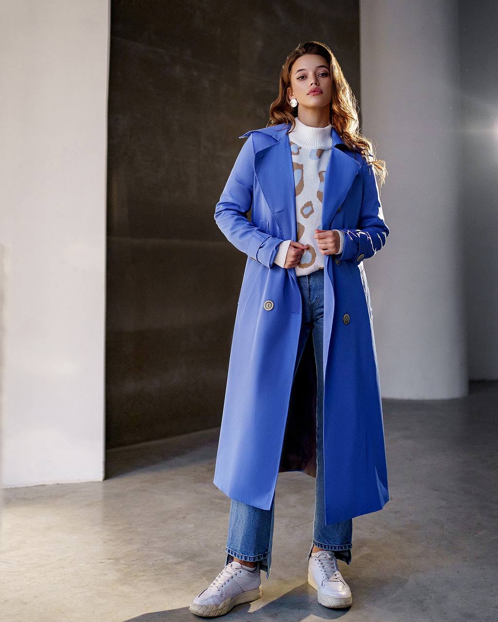 Woman wearing a blue coat in an indoor setting