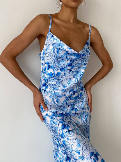 Woman wearing a blue floral dress against a plain background