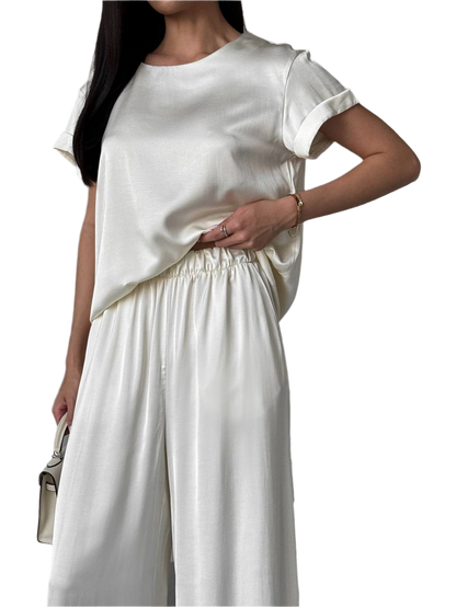 Woman wearing a white outfit with a plain background