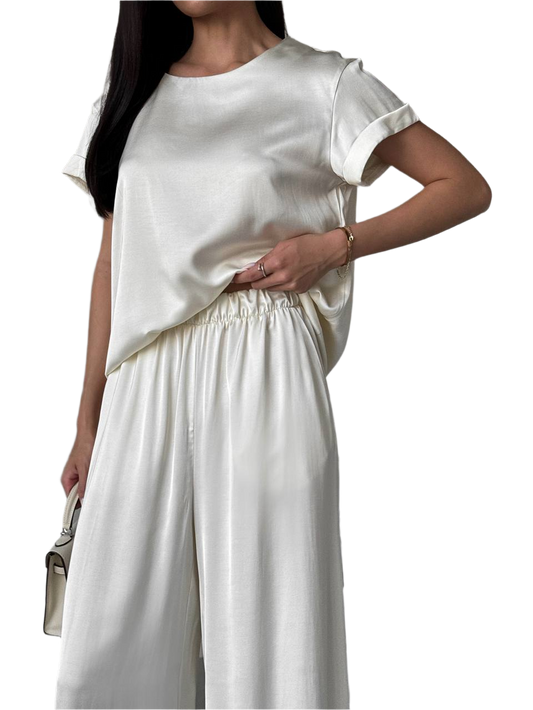 Woman wearing a white outfit with a plain background