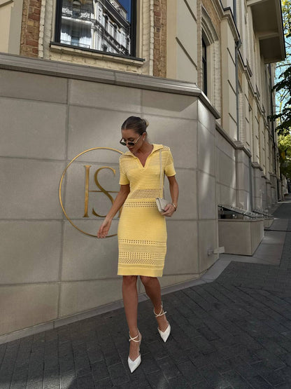 Woman in a yellow dress walking on a street with a building in the background