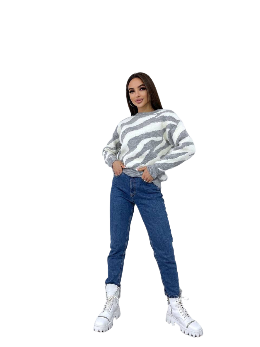 Woman wearing a striped sweater and blue jeans on a white background
