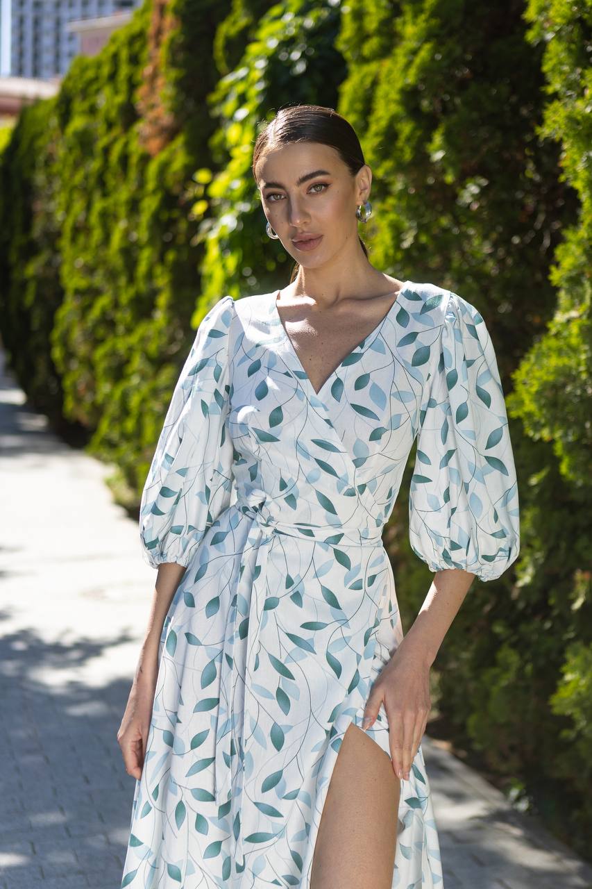 Woman wearing a white dress with blue leaf pattern outdoors