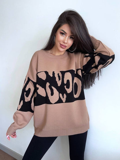 Woman wearing a beige sweater with black leopard print sleeves against a white background