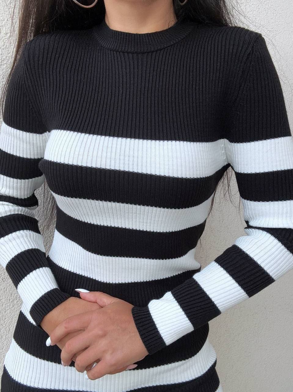 Black and white striped sweater worn by a person against a neutral background