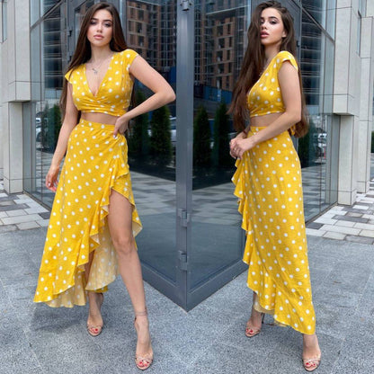 Woman in a yellow polka dot dress standing in front of a glass door.