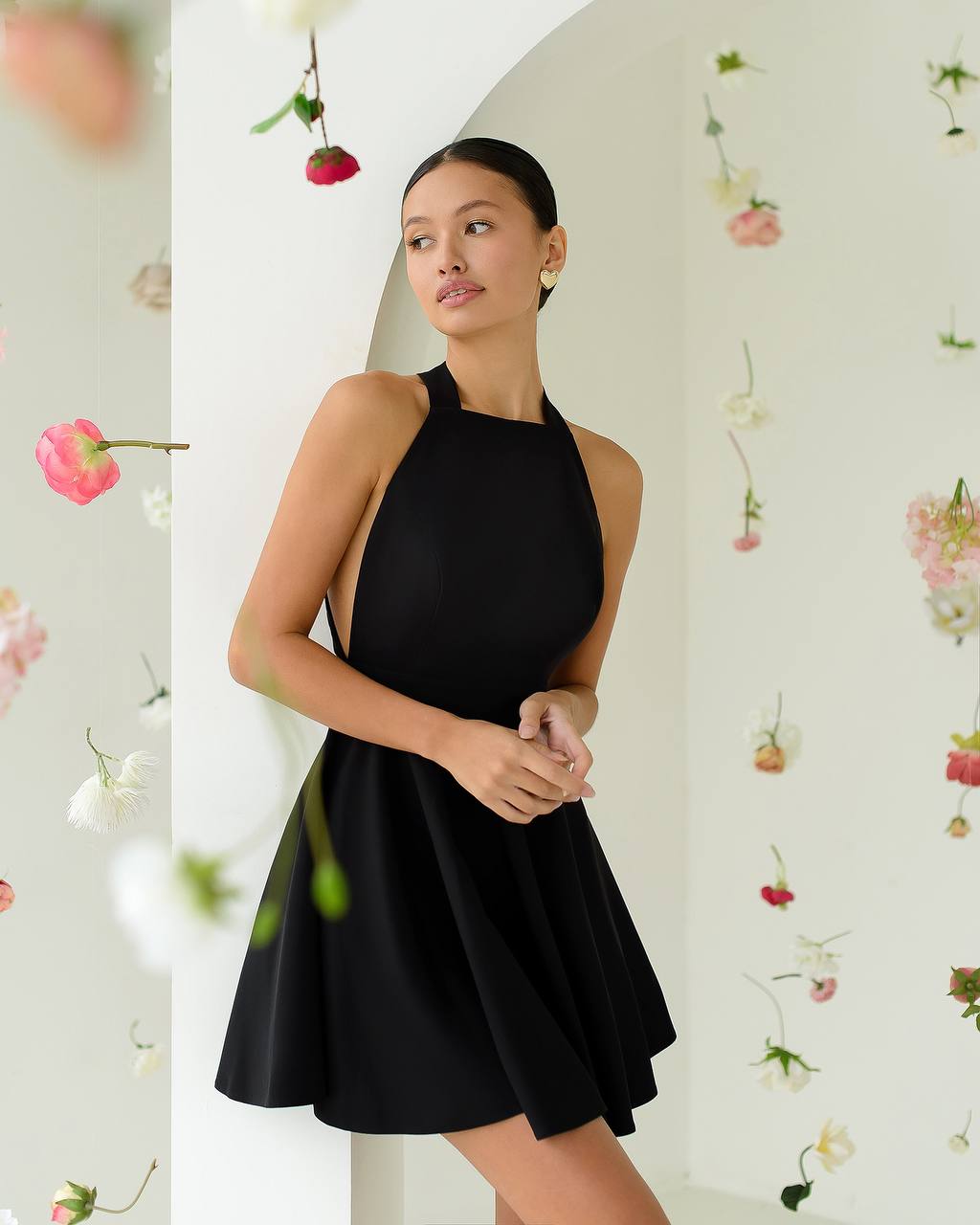 Woman wearing a black dress against a floral background