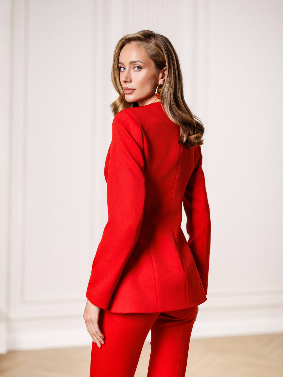 Woman wearing a red suit against a white background