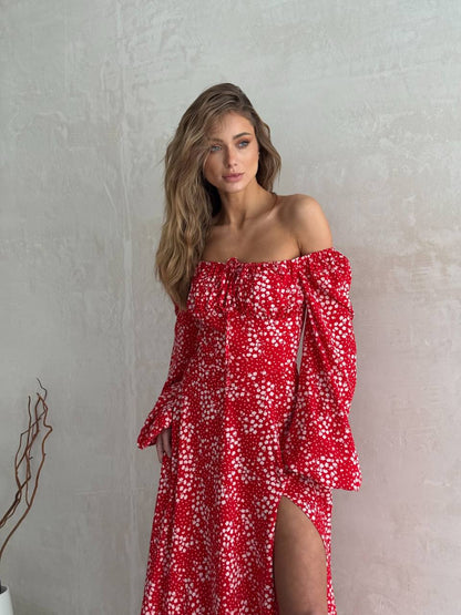 Woman wearing a red floral off-shoulder dress against a plain background