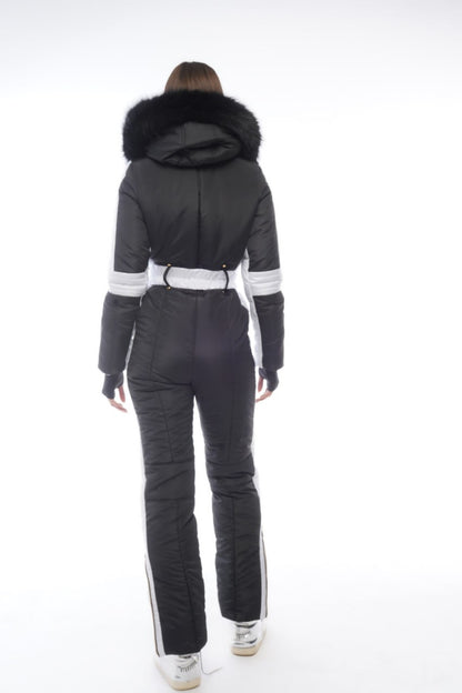 Person wearing a black ski suit with white accents on a white background
