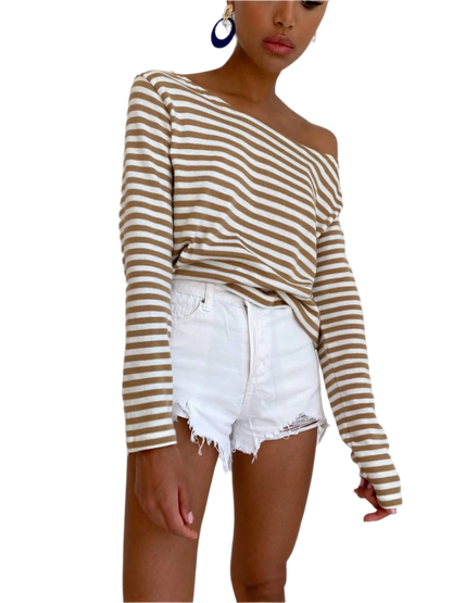 Woman wearing a striped long-sleeve top and white shorts on a white background