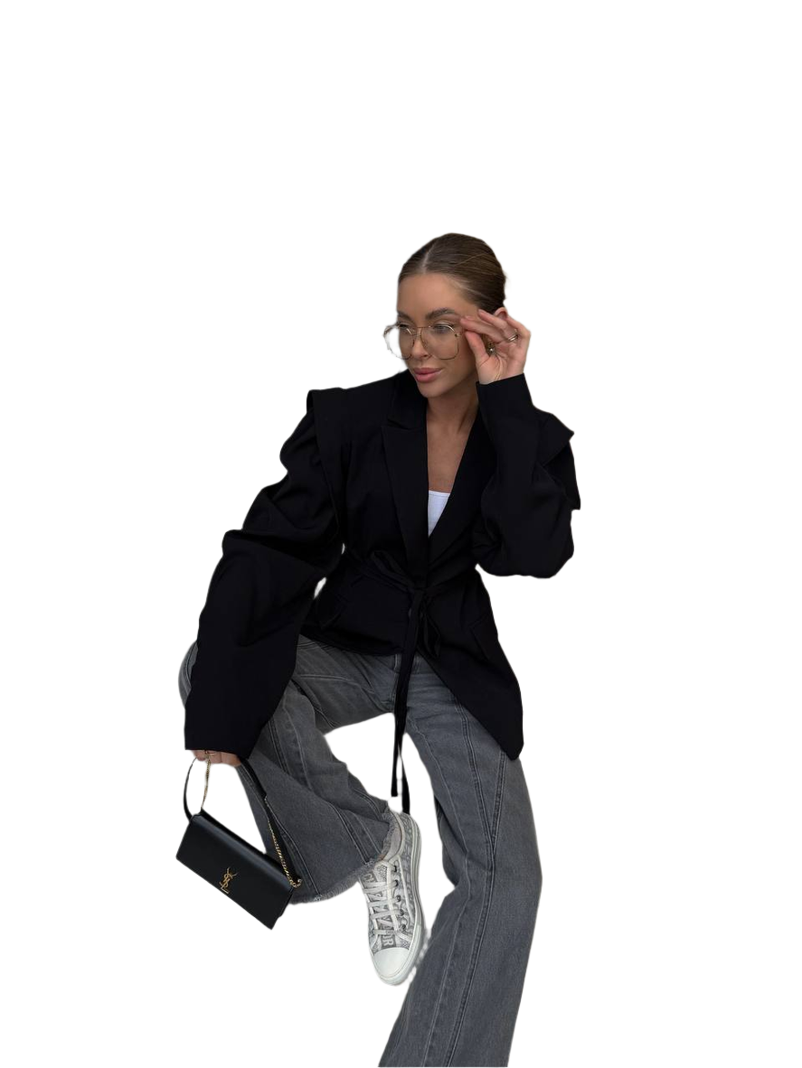 Person wearing a black coat and gray pants sitting on a white background