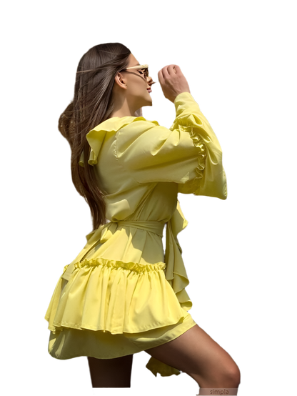 Woman wearing a yellow dress with ruffled details on a white background