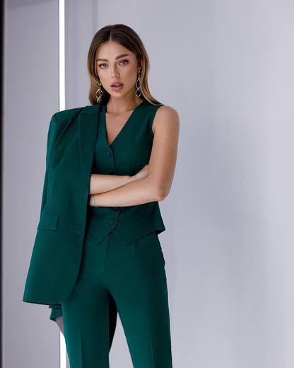 Woman wearing a green suit against a plain background