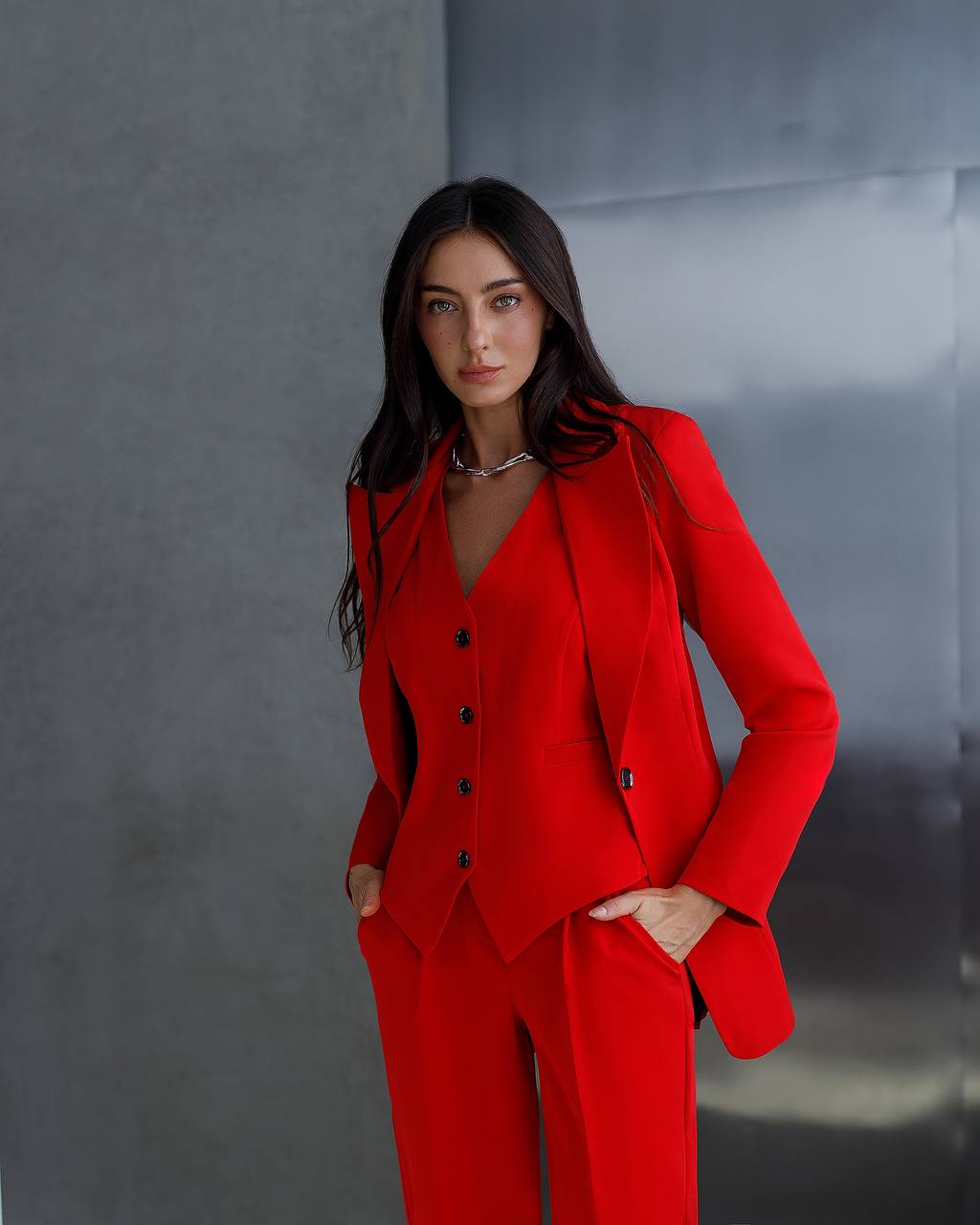 Woman wearing a red suit against a gray background