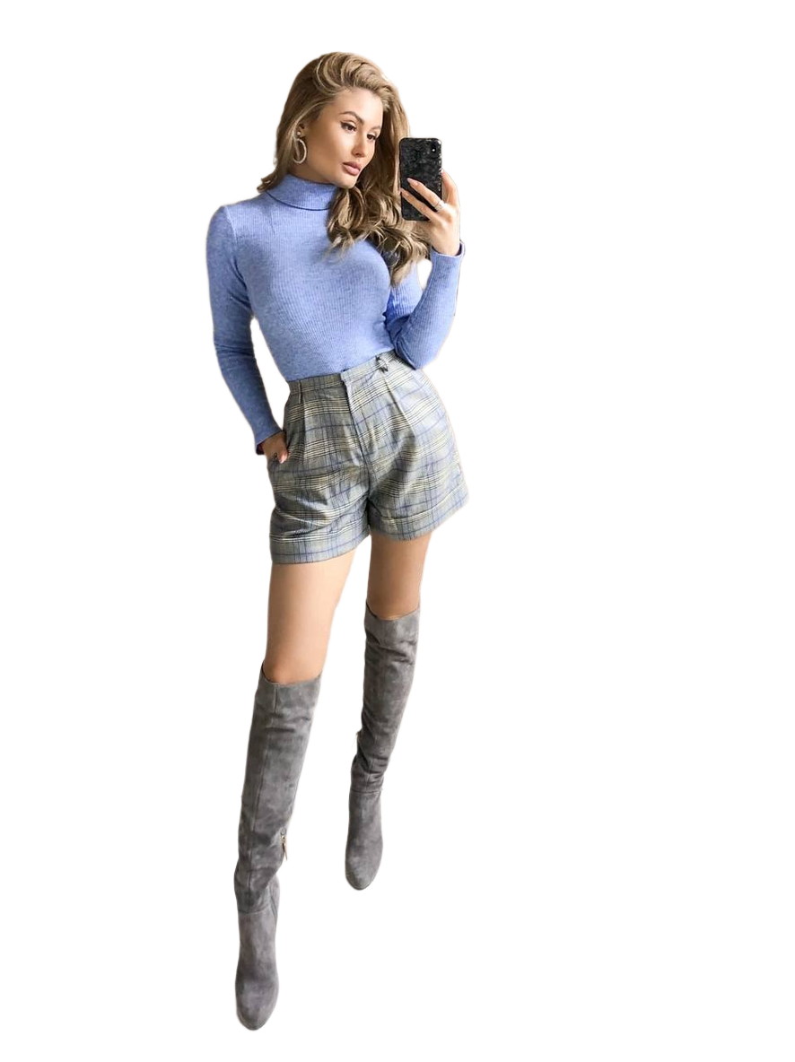 Woman wearing a blue turtleneck, plaid shorts, and gray knee-high boots on a white background