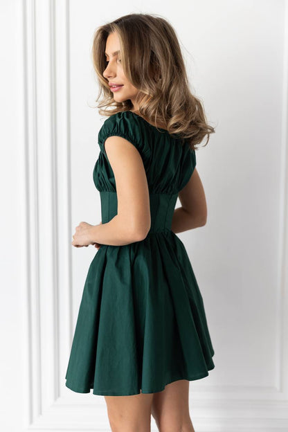Woman wearing a green dress against a white background