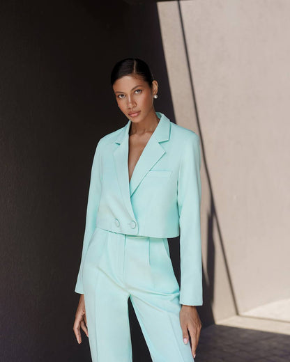 Woman wearing a light blue suit against a neutral background