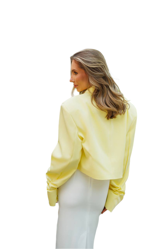 Woman wearing a light yellow blouse and white pants on a white background